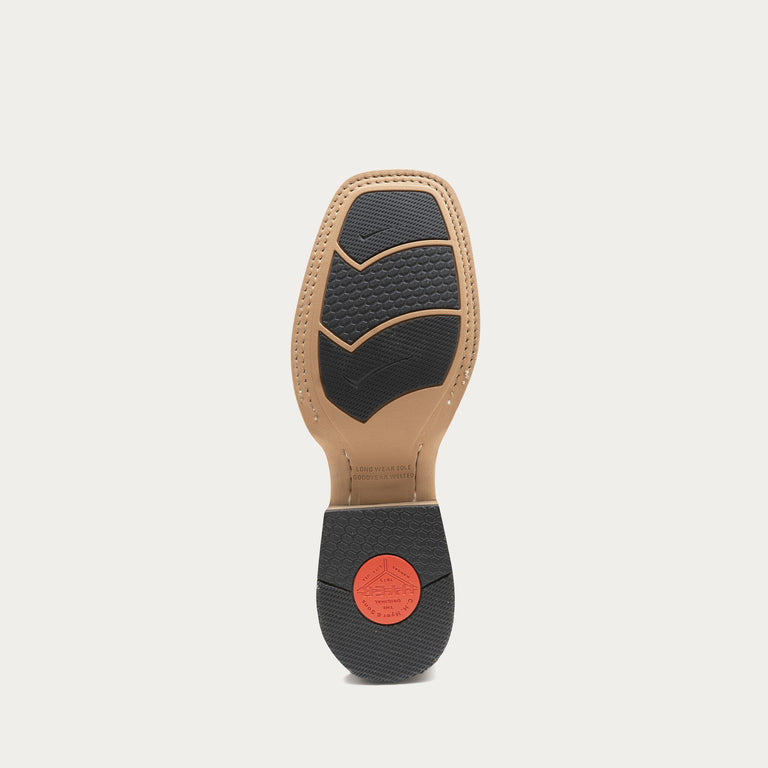 The outsole of a boot is shown from the bottom, featuring a tan leather footbed, black textured rubber tread, and a small red circular logo on the heel.