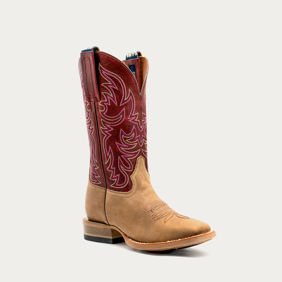 A single western cowboy boot in tan leather vamp with a burgundy leather shaft featuring detailed embroidered patterns, shown against a light gray background.