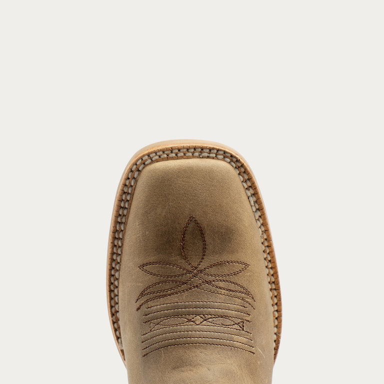 Close-up top view of a light tan leather cowboy boot showing the square toe, decorative stitching, and whipstitch edge against a light gray background.