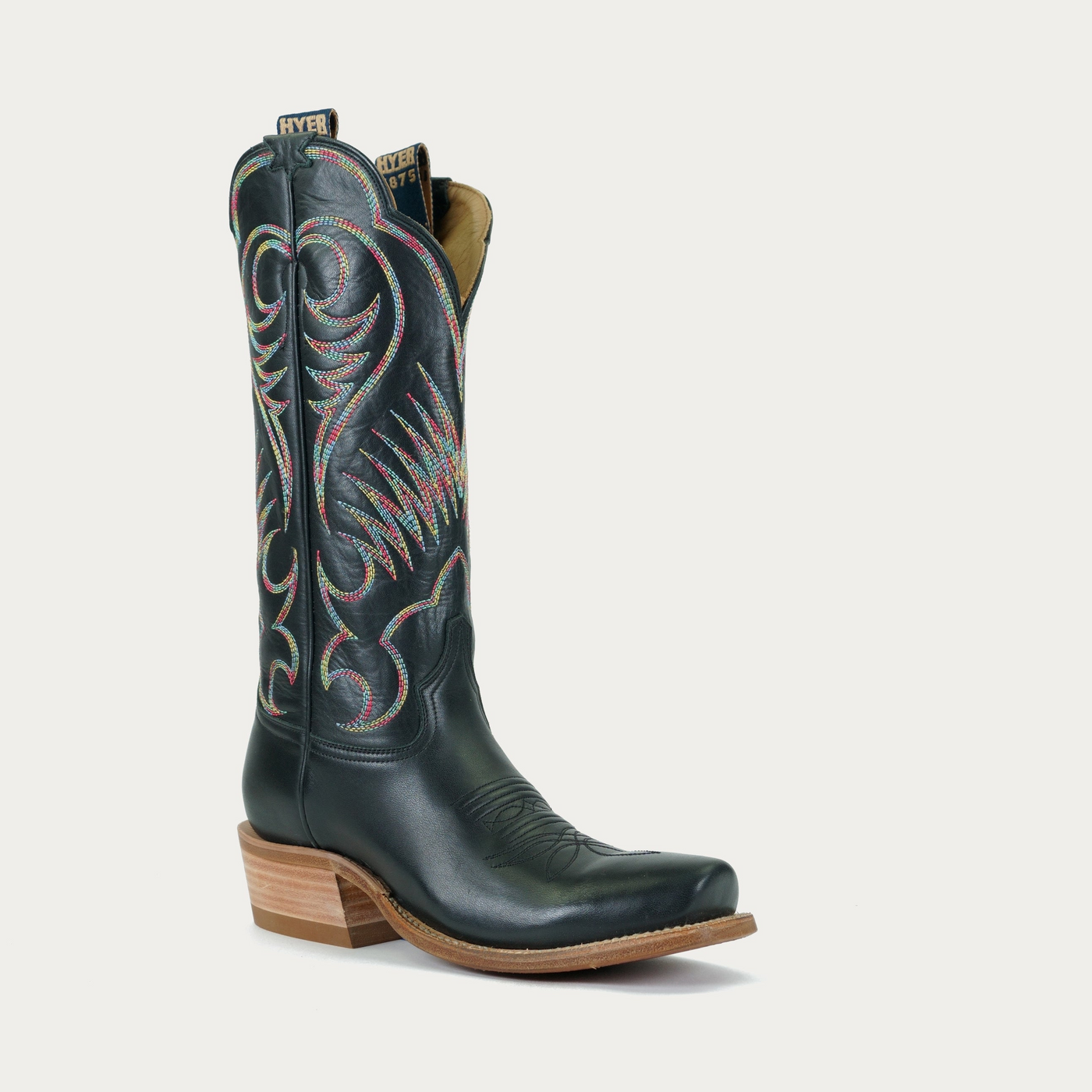 A black smooth leather cowboy boot with intricate mutlicolored embroidery and a brown wooden heel.