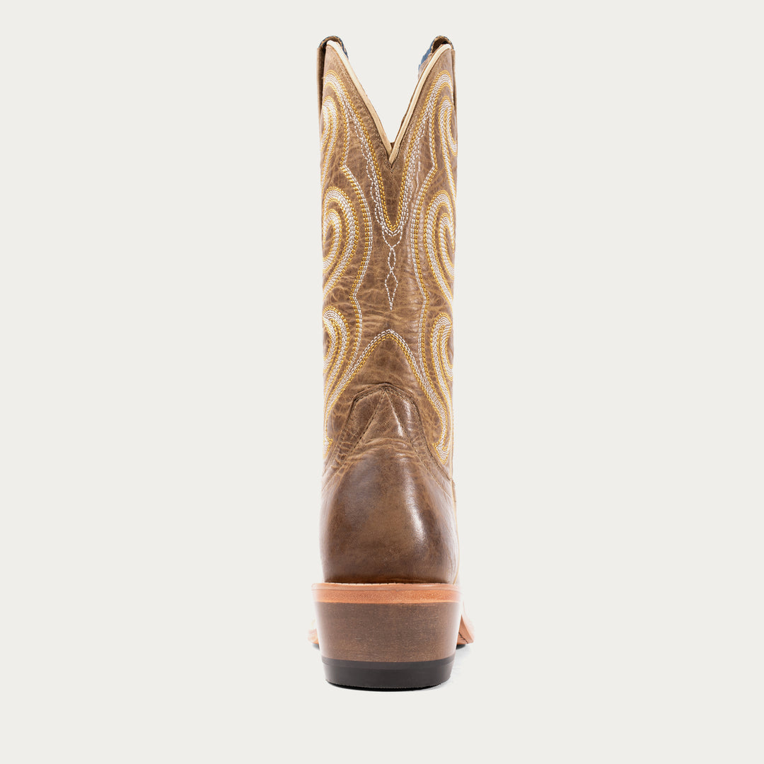 Brown cowboy boot with intricate stitching on a light gray background