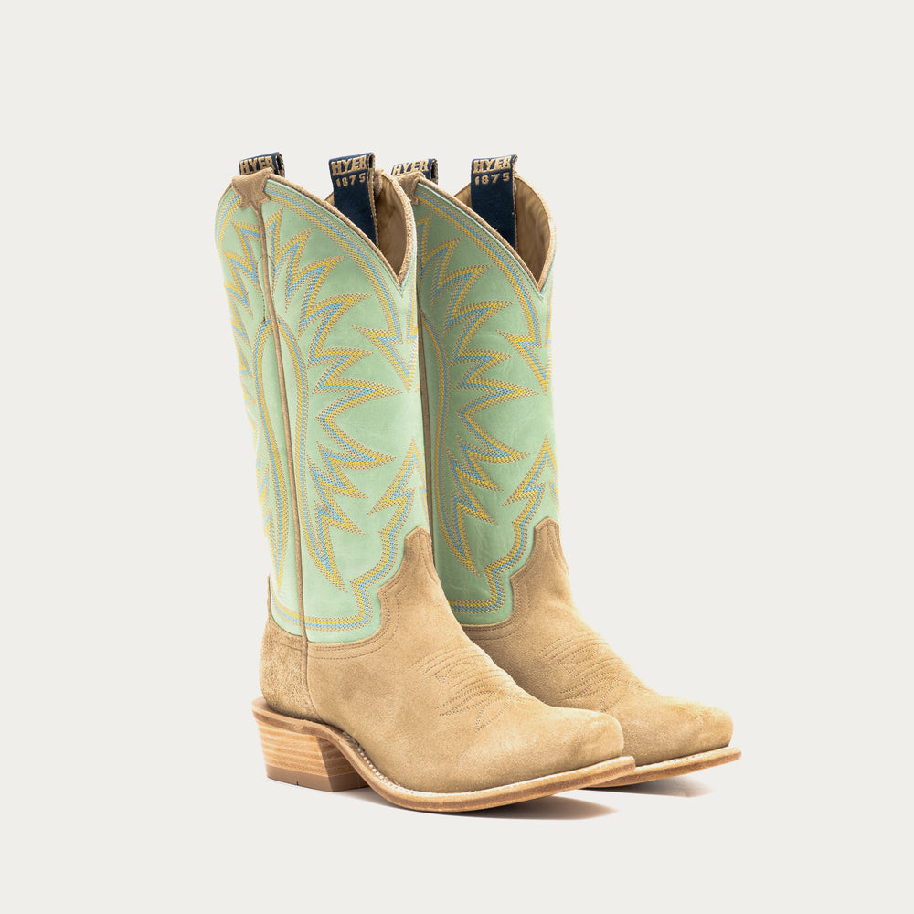 Pair of tan cowboy boots with light green uppers on a white background