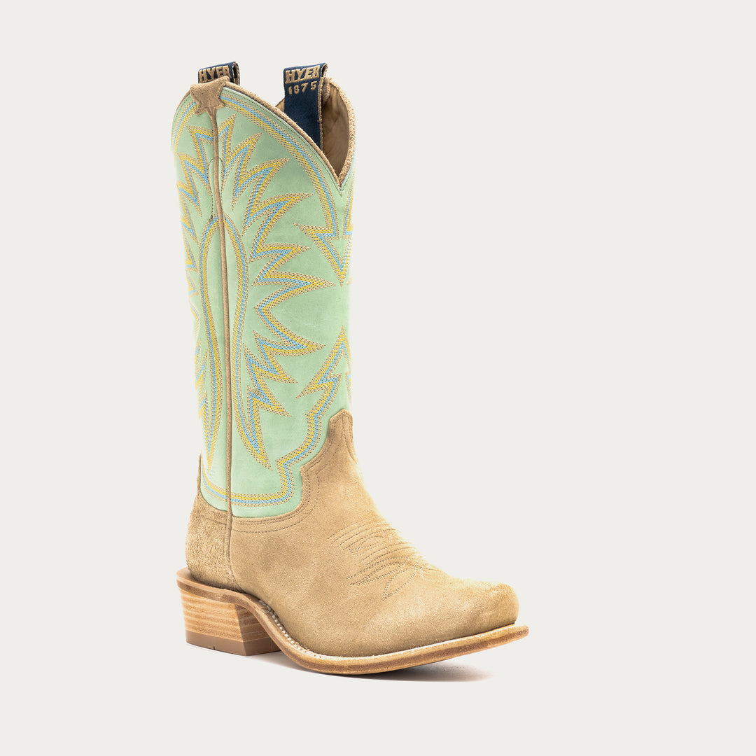Tan cowboy boot with green embroidered shaft on a light gray background