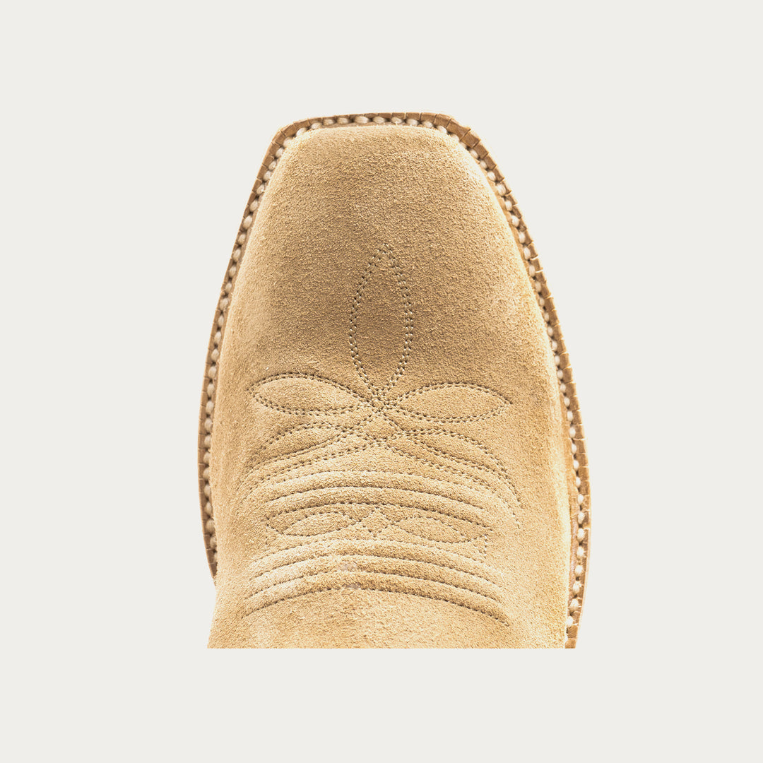 Close-up of a tan suede boot with decorative stitching on a light gray background