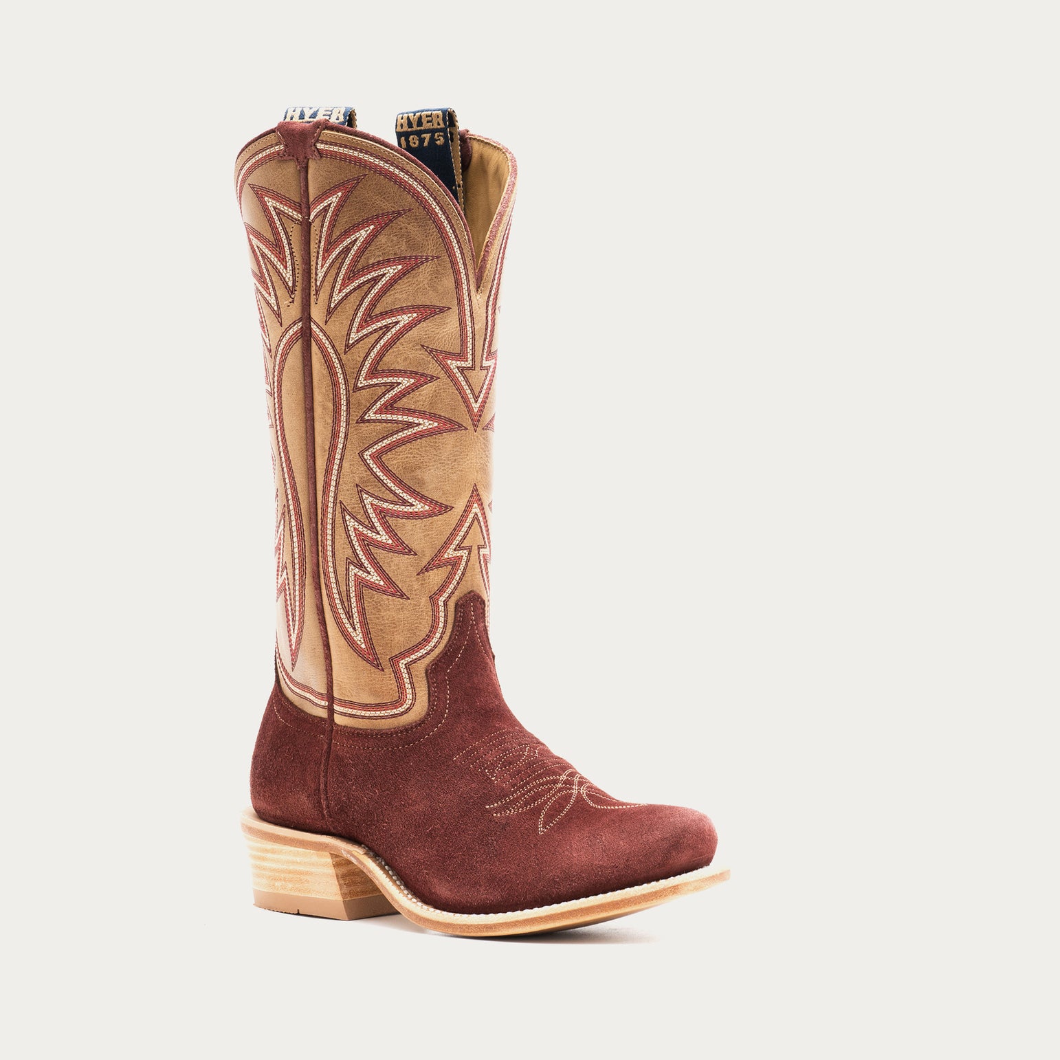 Burgundy and tan cowboy boot with intricate stitching on a light gray background