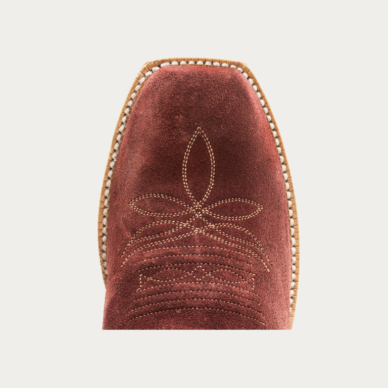Burgundy suede boot toe with decorative stitching on a light gray background