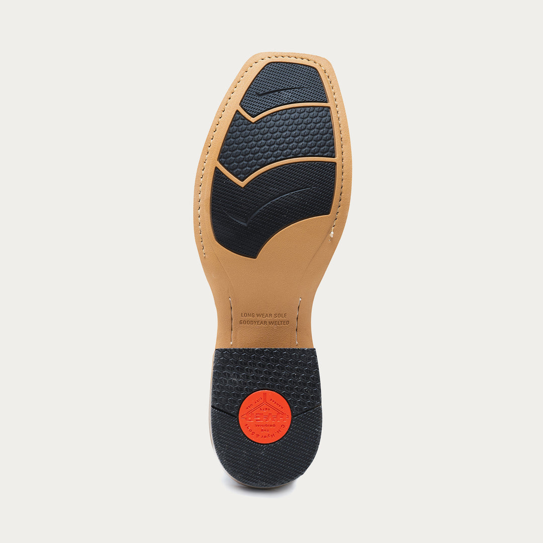 Tan shoe sole with black rubber inset tread pattern on a light gray background