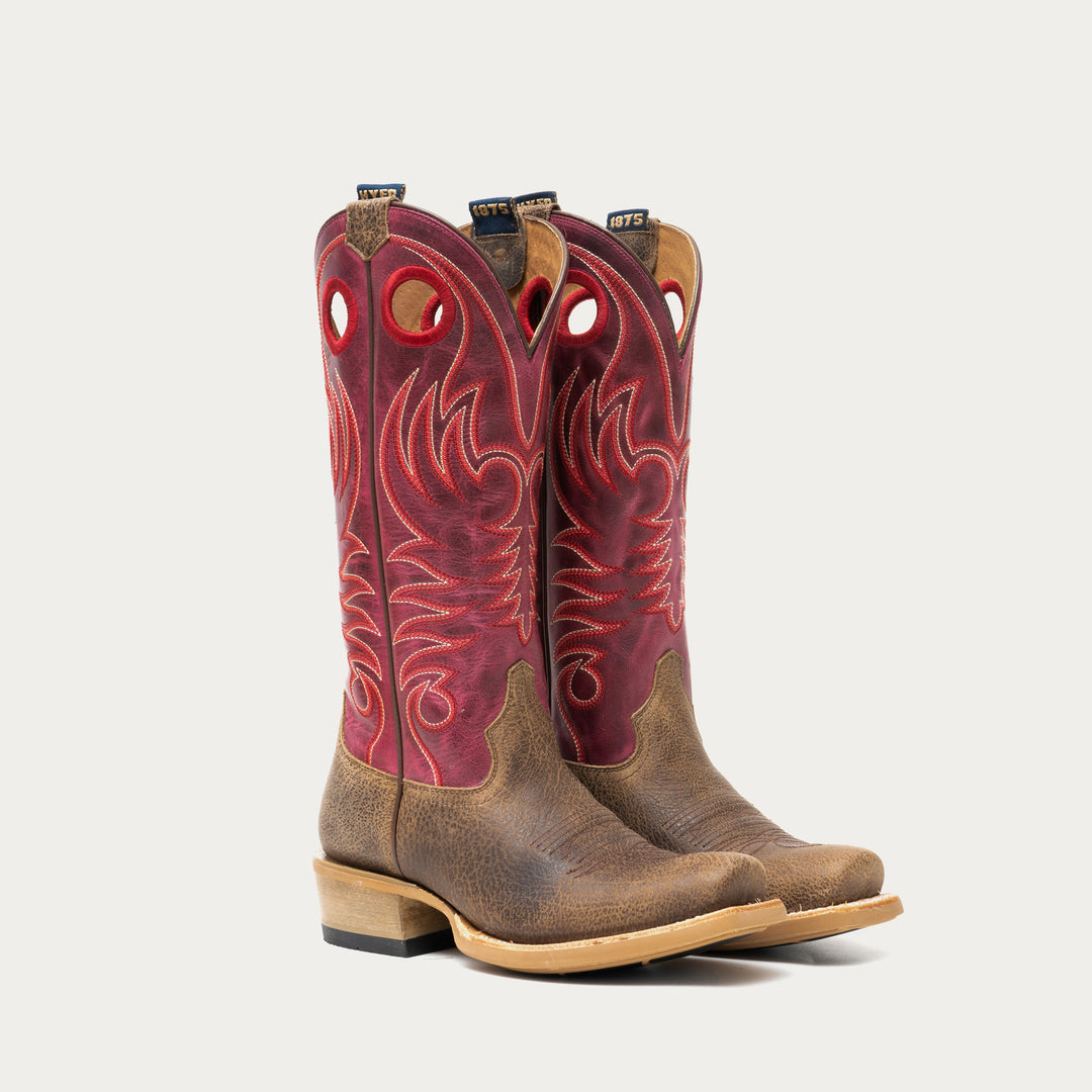 Pair of brown and dark pink cowboy boots on a light gray background