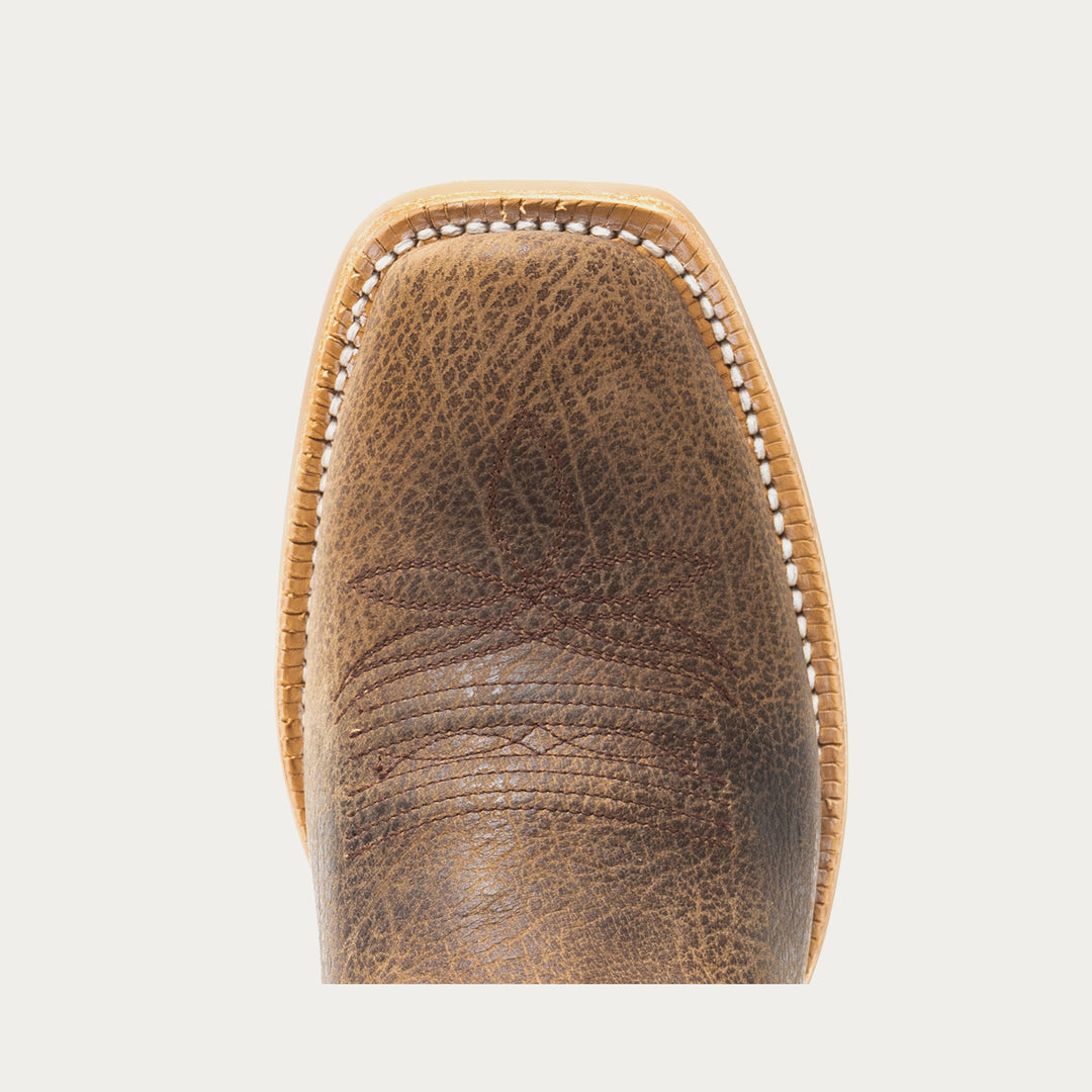 Close-up of a brown leather boot toe on a light gray background