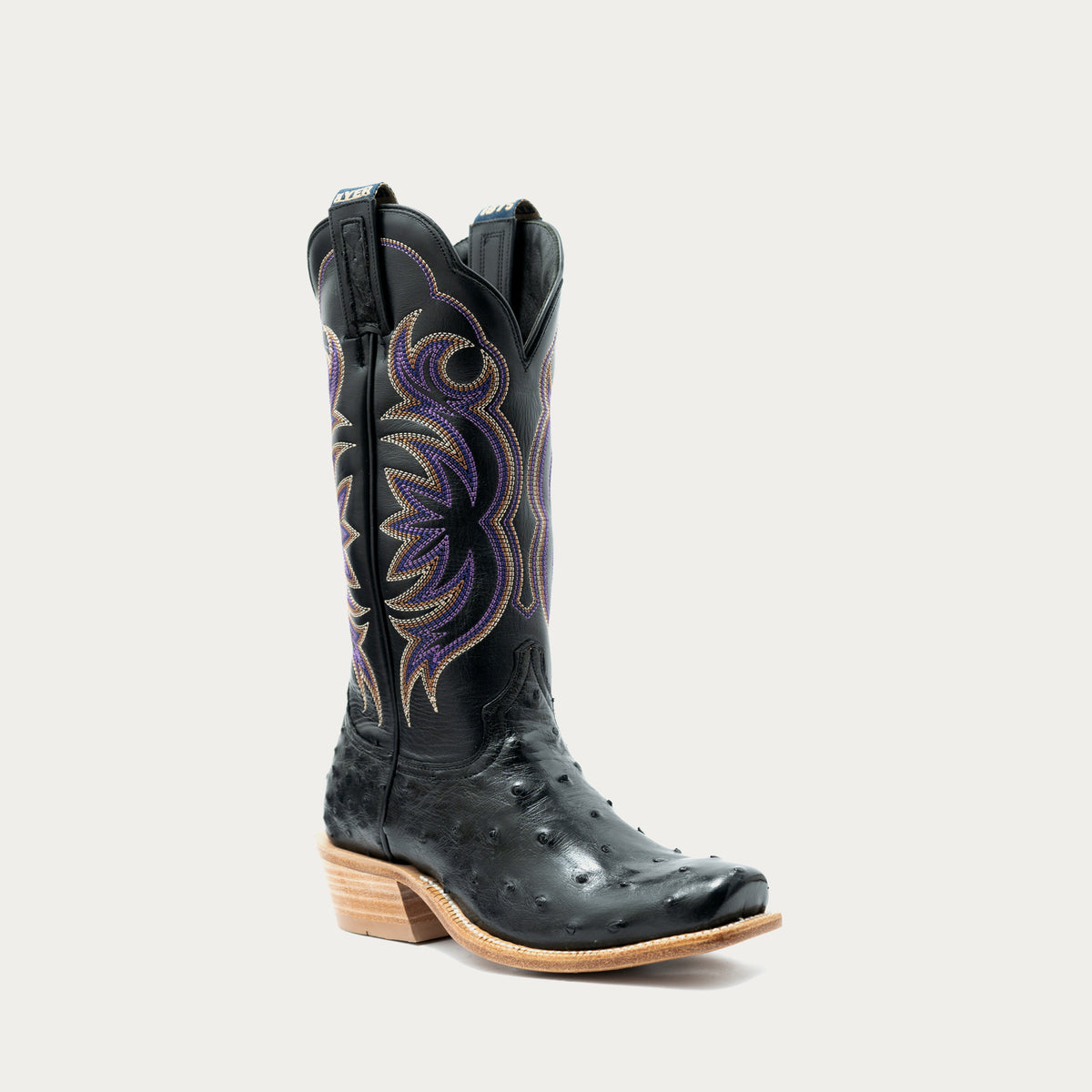 A single black ostrich leather cowboy boot with purple and gold embroidered western detailing on the shaft, set against a plain white background.
