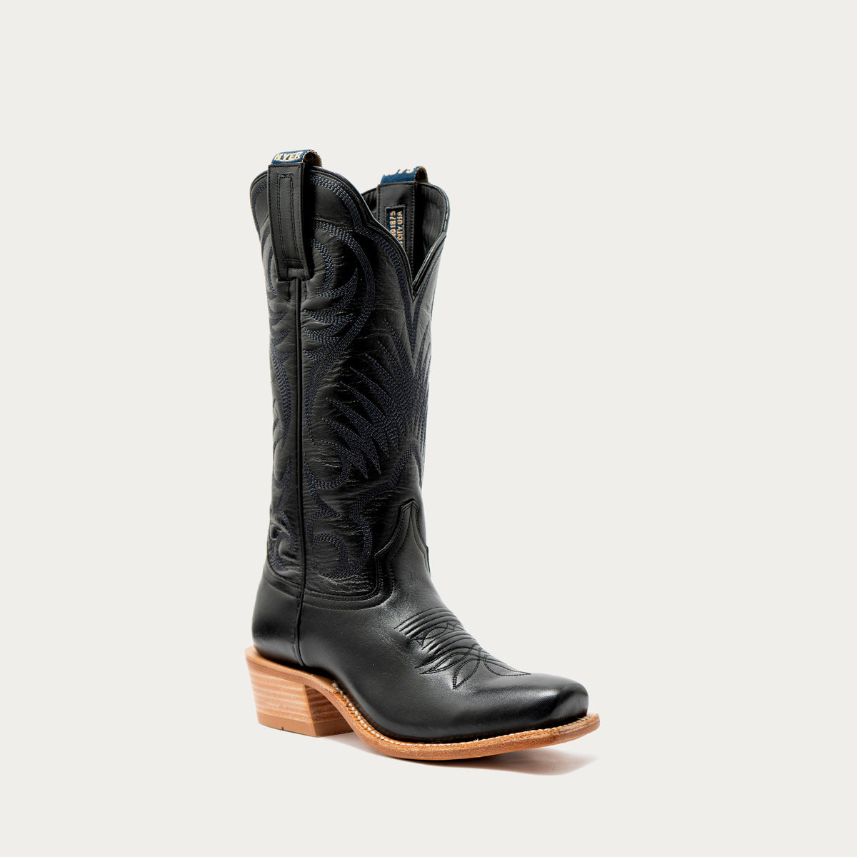 A single black leather cowboy boot with decorative stitching, a cutter toe, and a stacked leather heel, shown on a light gray background.