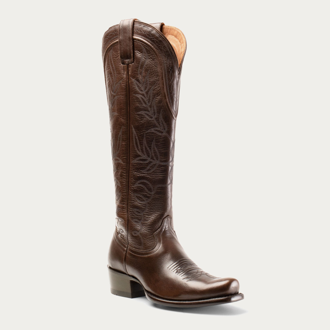 A single brown, leather, square-toe boot with intricate embossed patterns and a low heel on a white background.