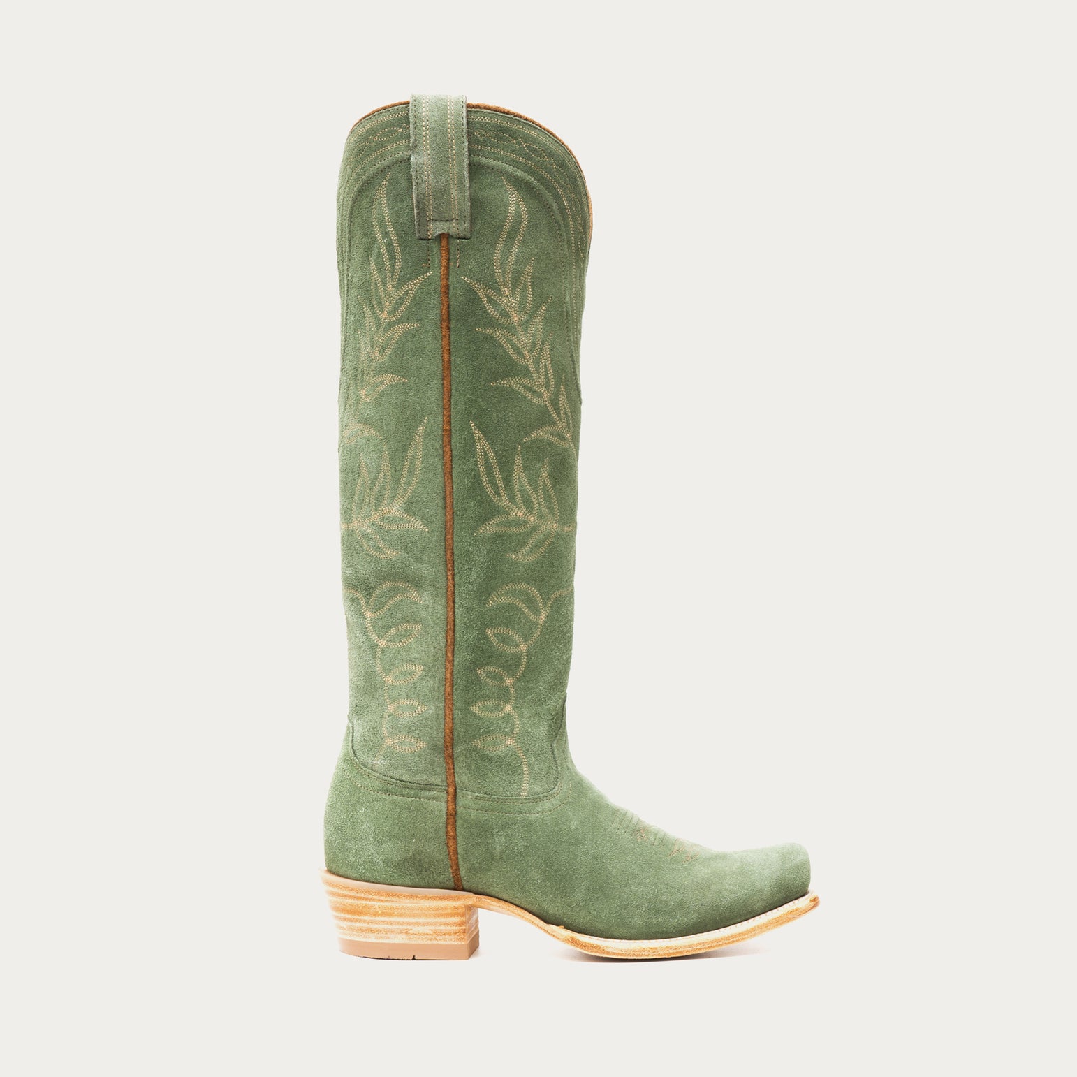 Tall green cowboy boot with embroidery on a light gray background