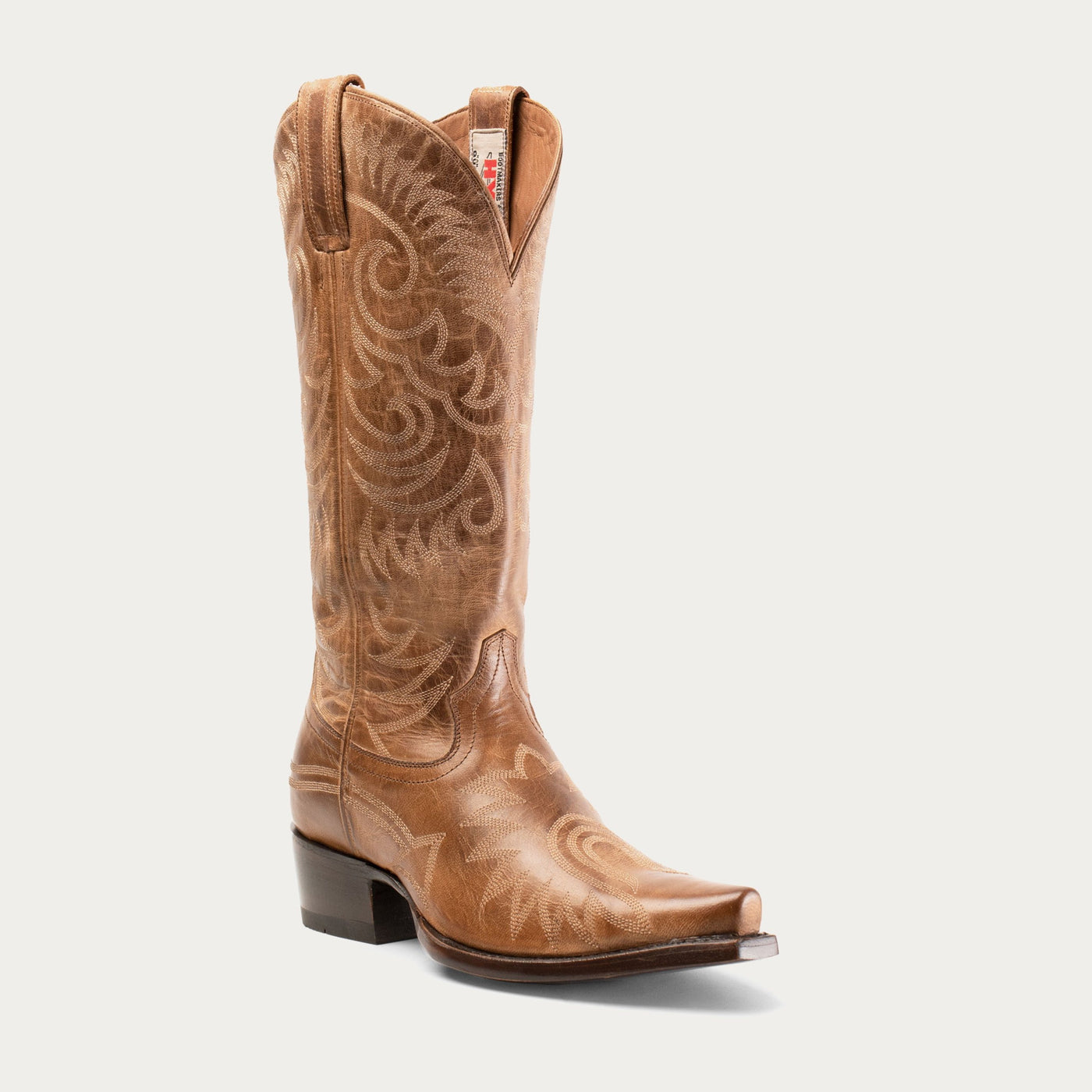 A brown leather cowboy boot with full-boot embroidery and a pointed toe.