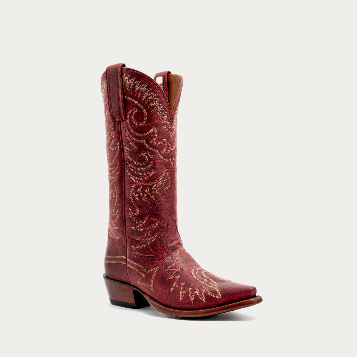 Red cowboy boot with white embroidery on a white background