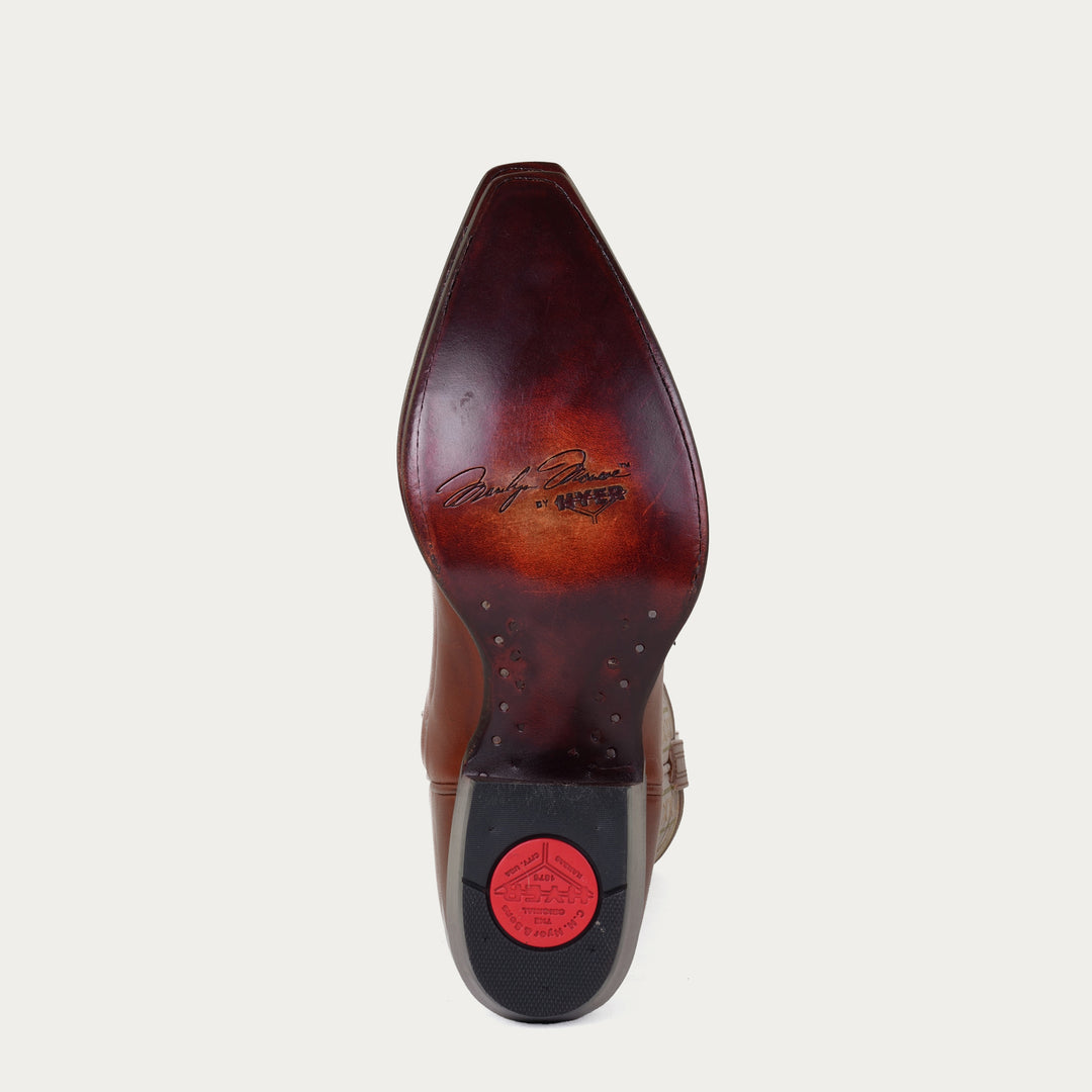 Brown leather sole of cowboy boot with "Marilyn Monroe by HYER" stamped on sole on a light gray background