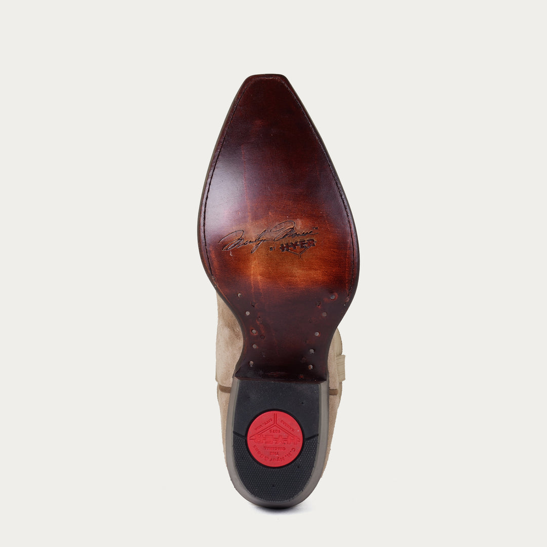 Brown leather sole of cowboy boot with "Marilyn Monroe by HYER" stamped on sole on a light gray background
