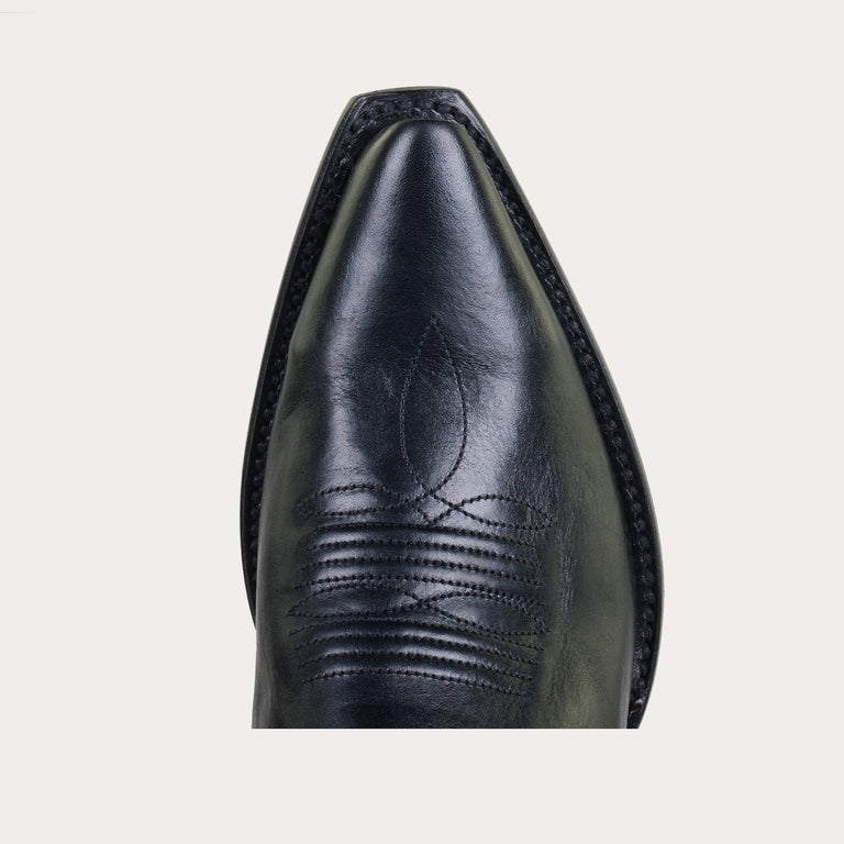 Close-up of a black leather boot with detailed stitching on a light gray background