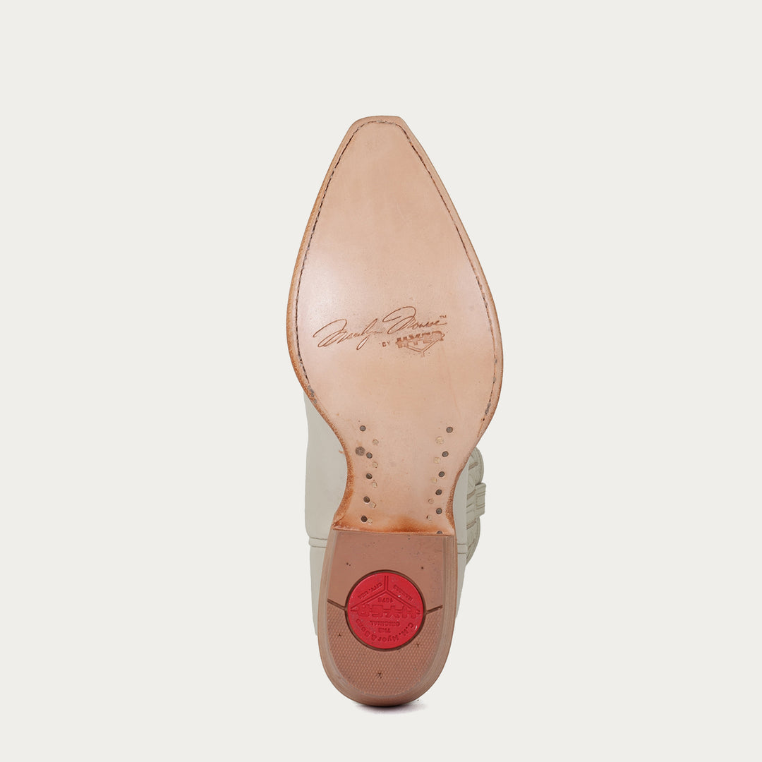 Tan leather sole of cowboy boot with "Marilyn Monroe by HYER" stamped on sole on a light gray background