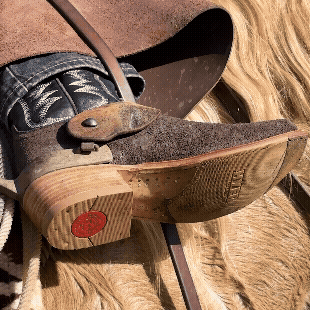 GIF showing cowboy boot and sole resting against horse and reins