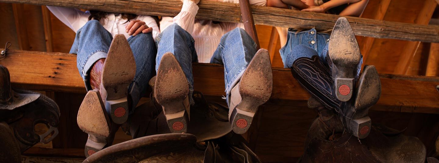Close-up of Hyer cowboy boots from below showing the signature red heel on the soles